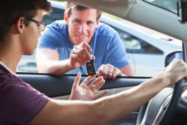 Father handing son keys